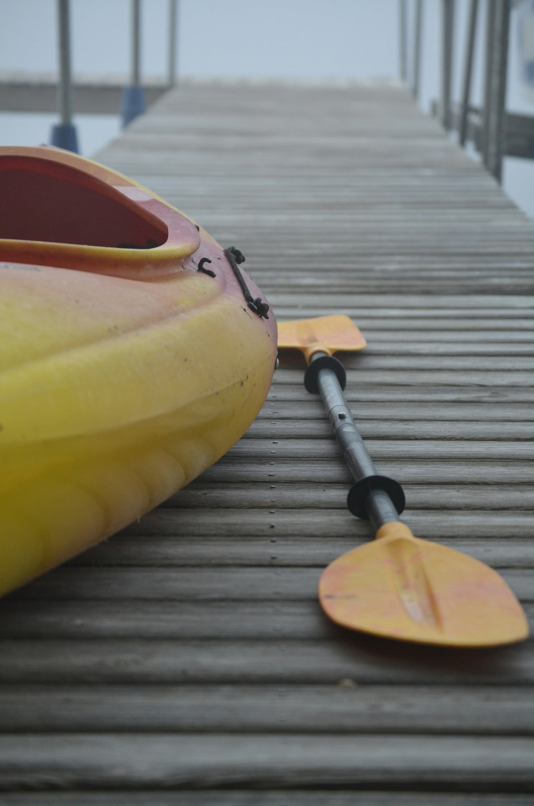 yellow and red plastic kayak on wooden surface