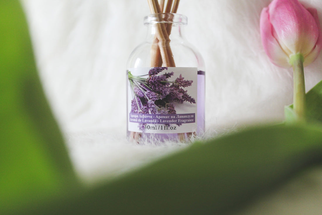 a bottle filled with purple flowers next to a pink tulip
