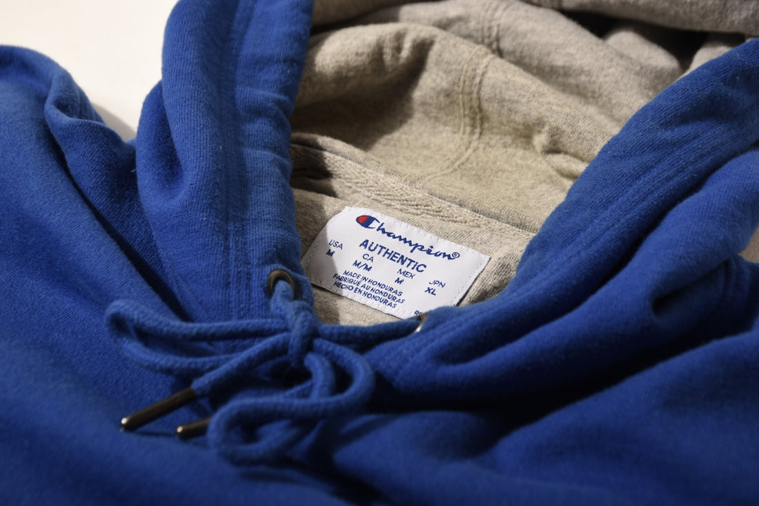 a close up of a blue hoodie with a tag on it