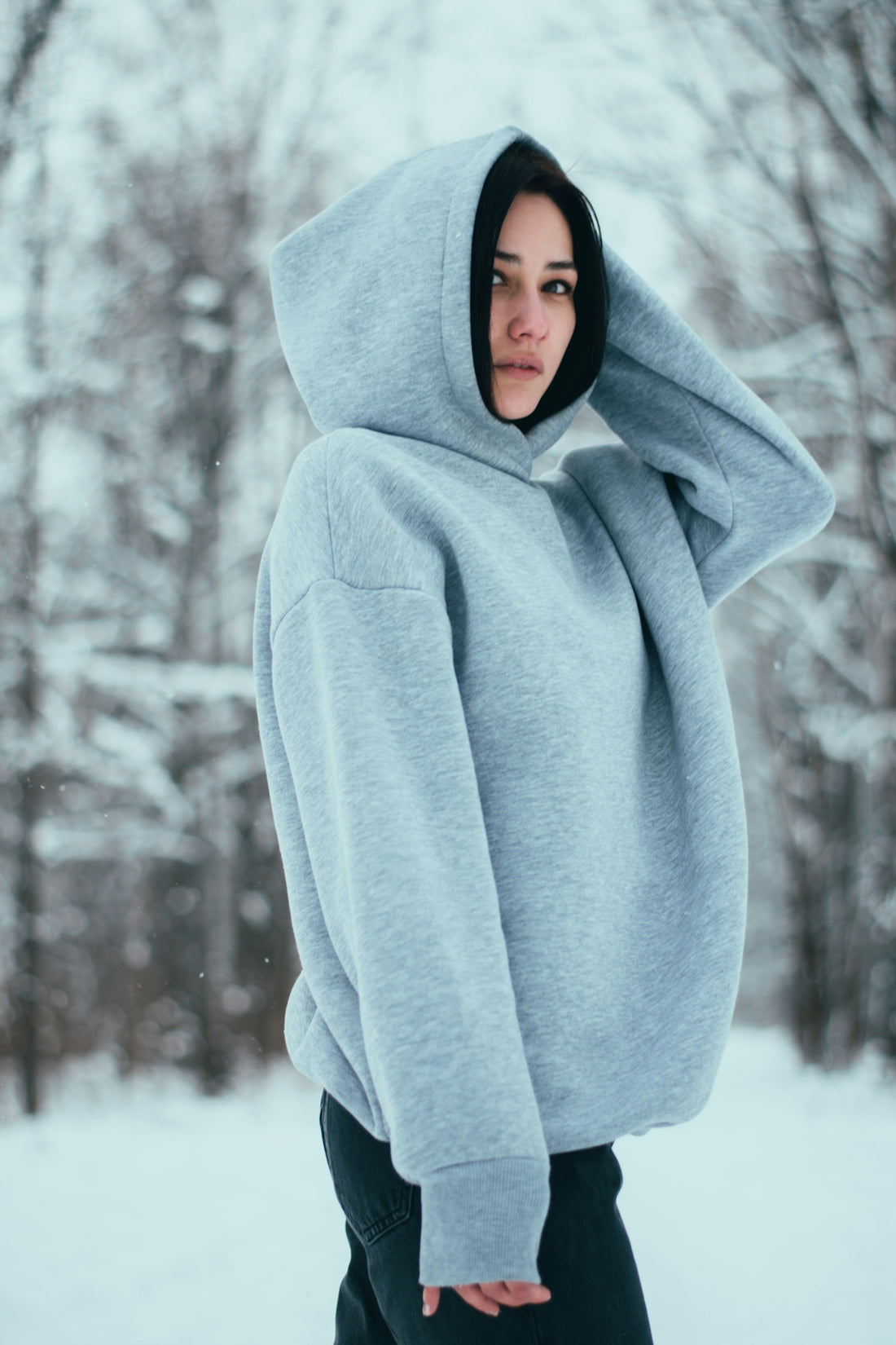 a woman wearing a hoodie in the snow