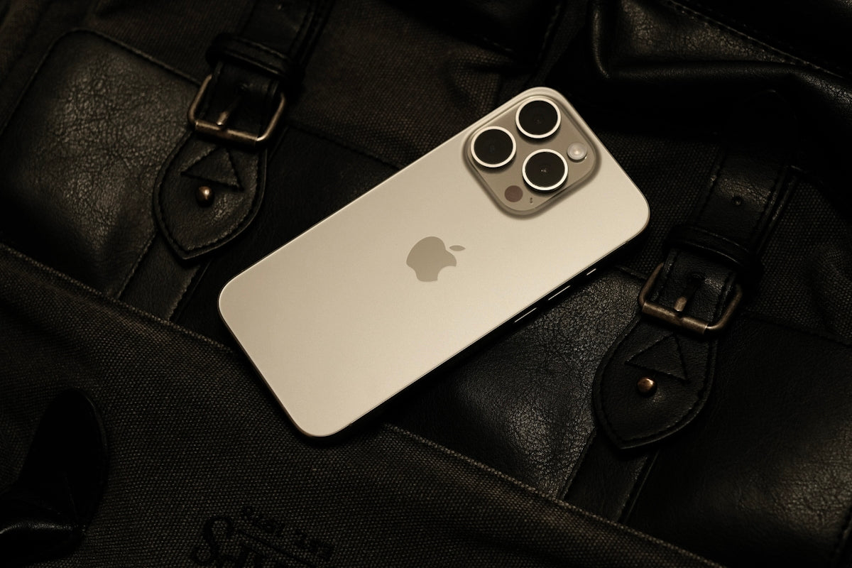 a white iphone sitting on top of a black bag