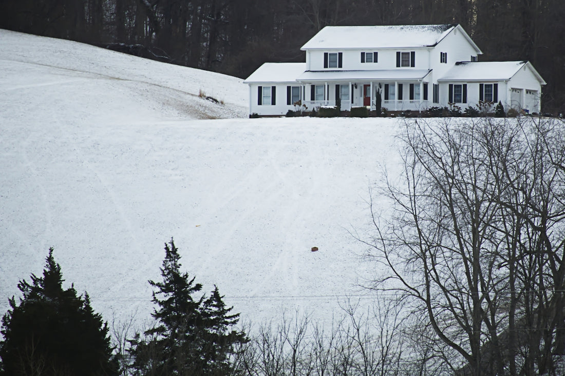 A large white house sitting on top of a snow covered hill